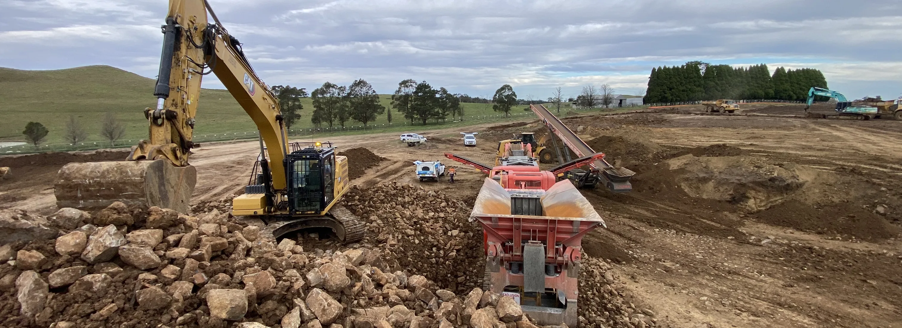Excavator and mobile crusher working bulk earthworks