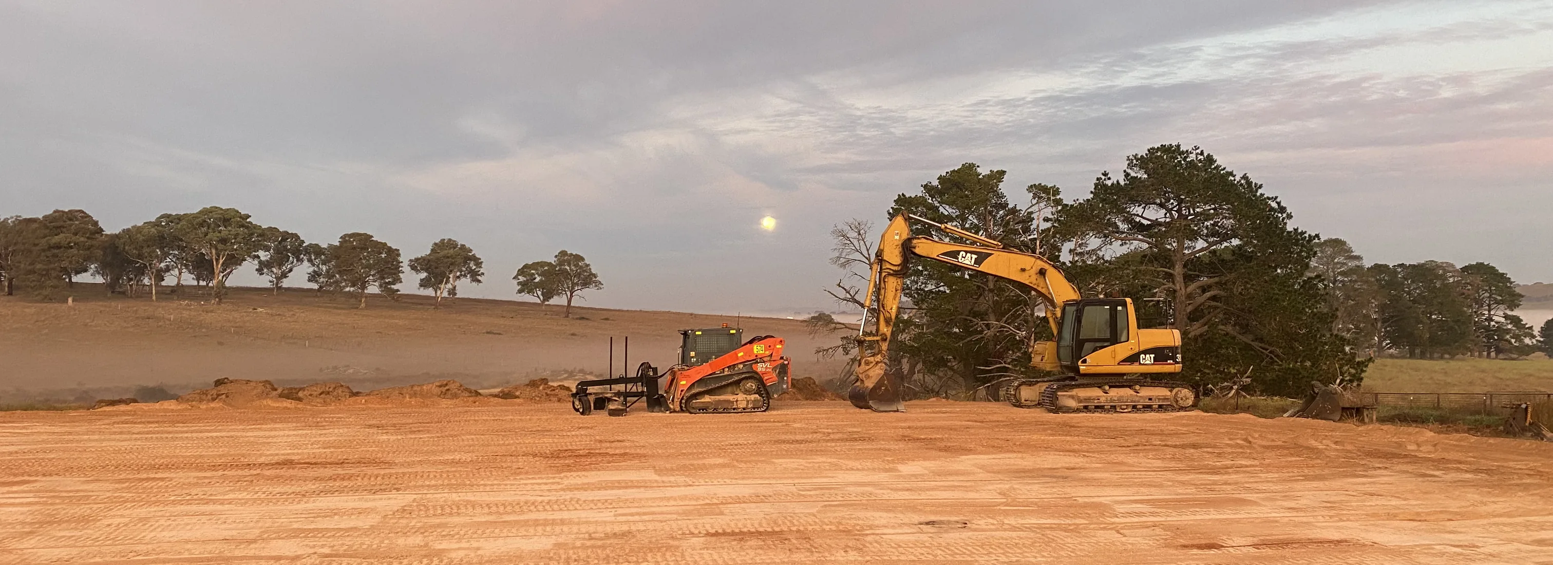 Grading a rural site at dusk