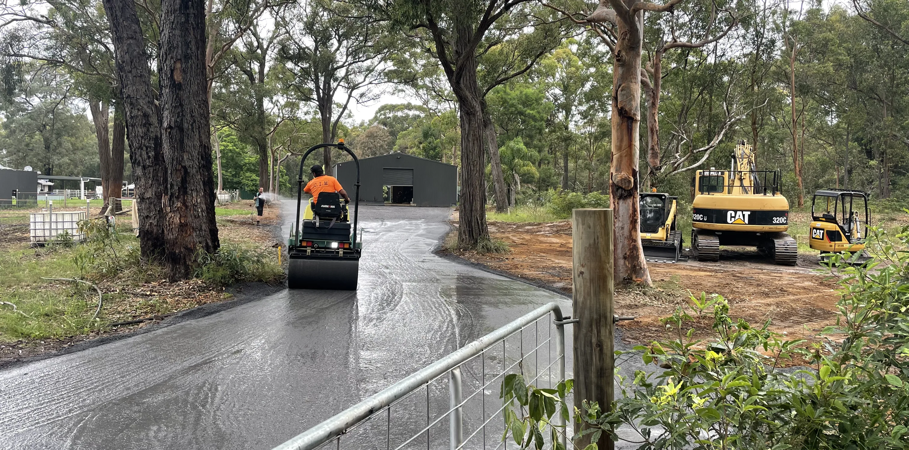 Roller and excavator finishing a rural access road