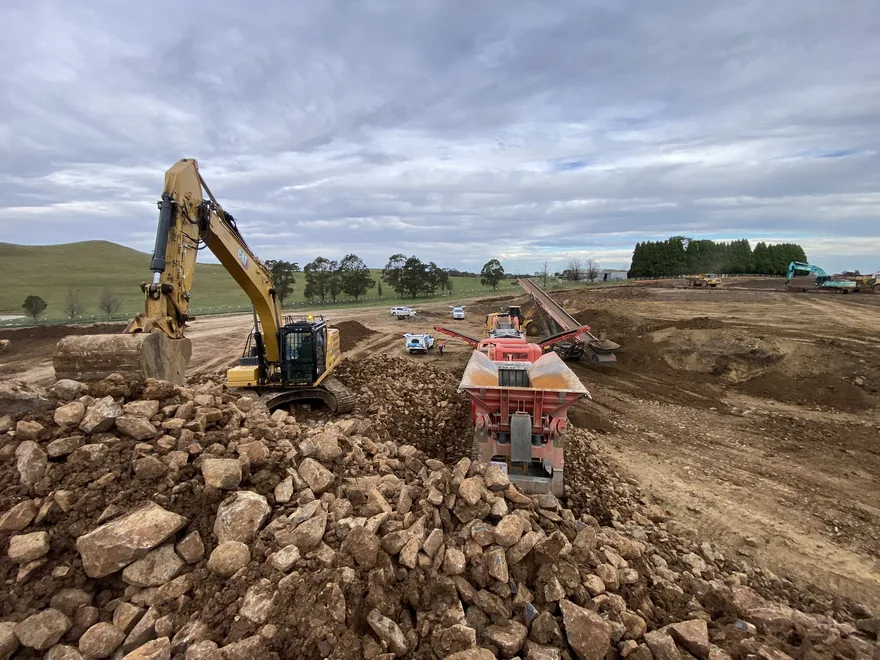Excavator and mobile crusher working rock