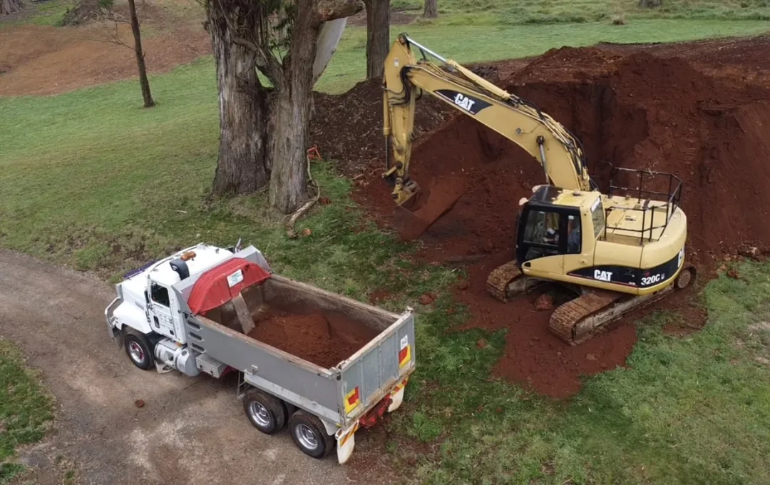 Excavator loading a truck during earthmoving works