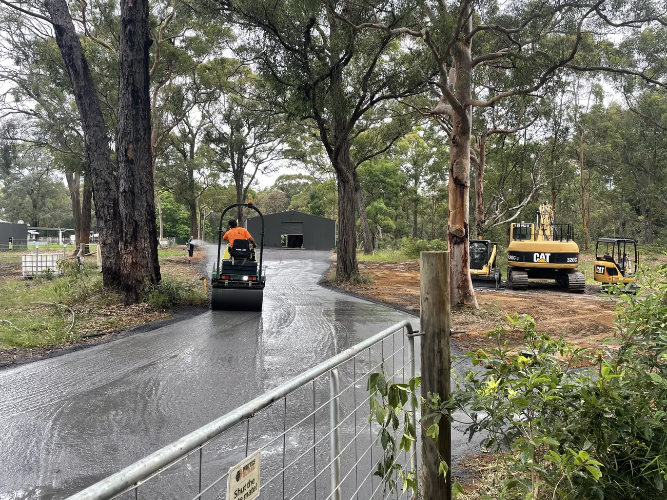 Roller compacting a new access road on a rural property